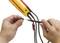 A person is holding an electrical testing device and connecting cables with a measuring probe to measure the voltage.