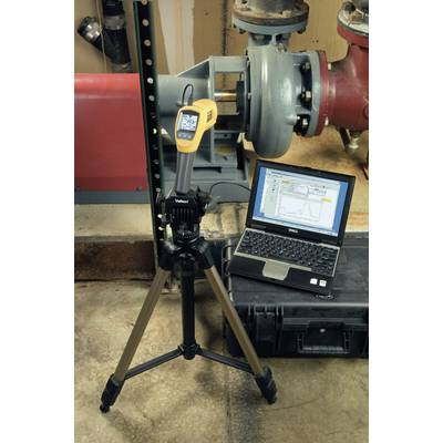 A laptop displays a diagram showing the data from a measuring device connected to a pipe. A tripod holds the measuring device.