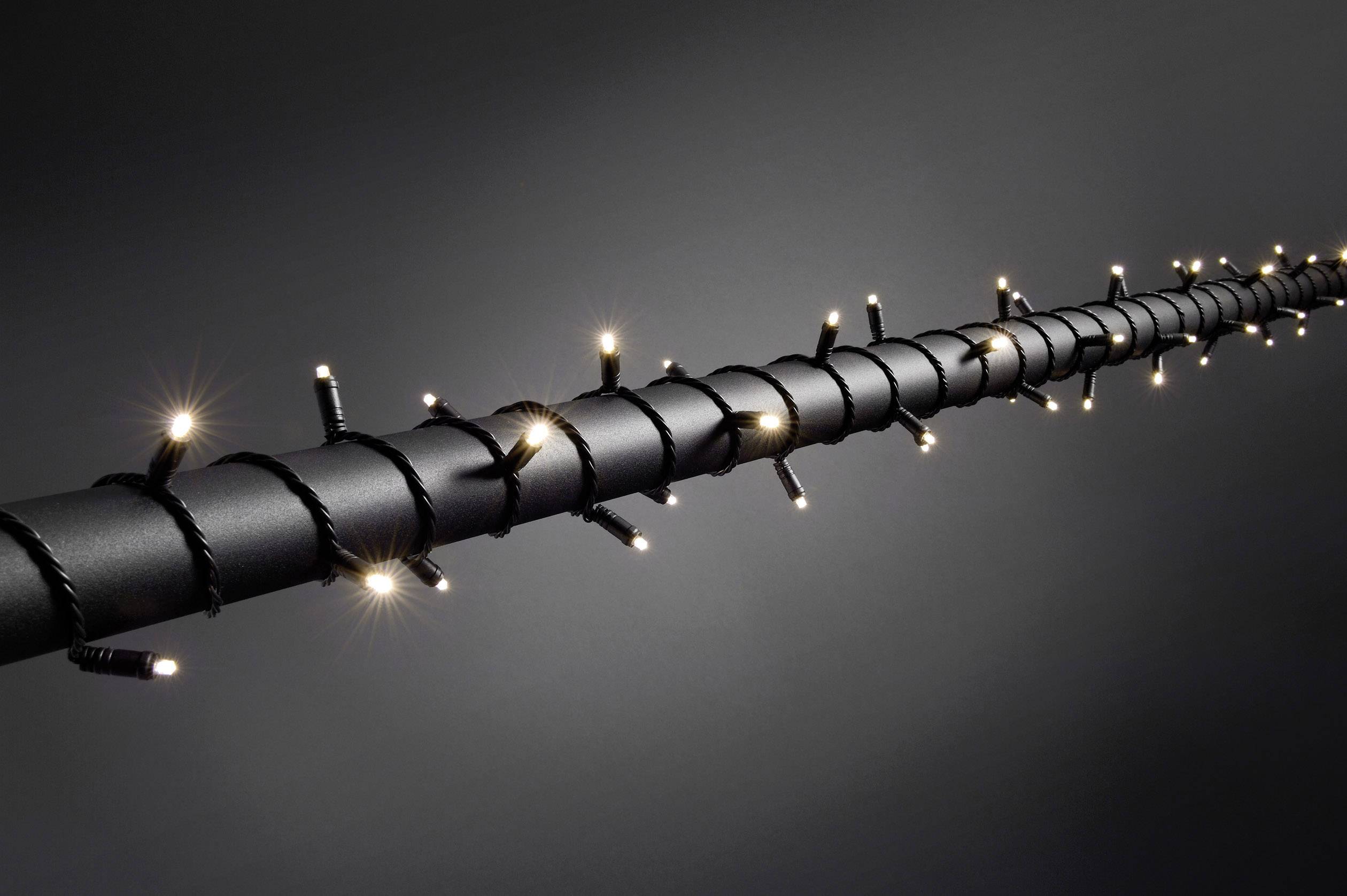 Black staff, wrapped with twinkling, small Christmas lights, arranged evenly and linearly.