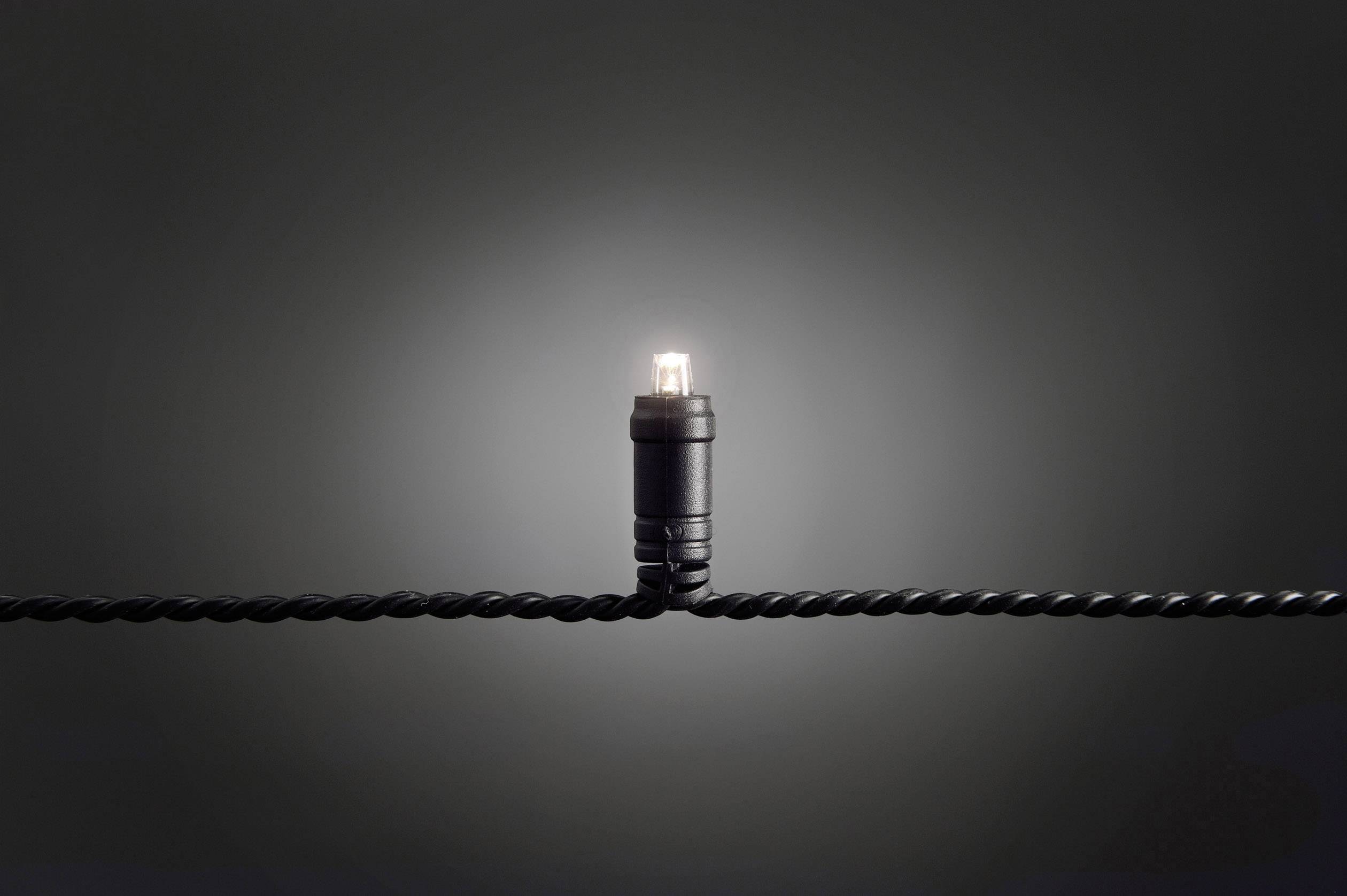 A single white LED light illuminates on a black, twisted cable against a dark background.