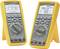 Two digital multimeters with yellow casings display measurement values and diagrams on their screens, suitable for electrical measurements.