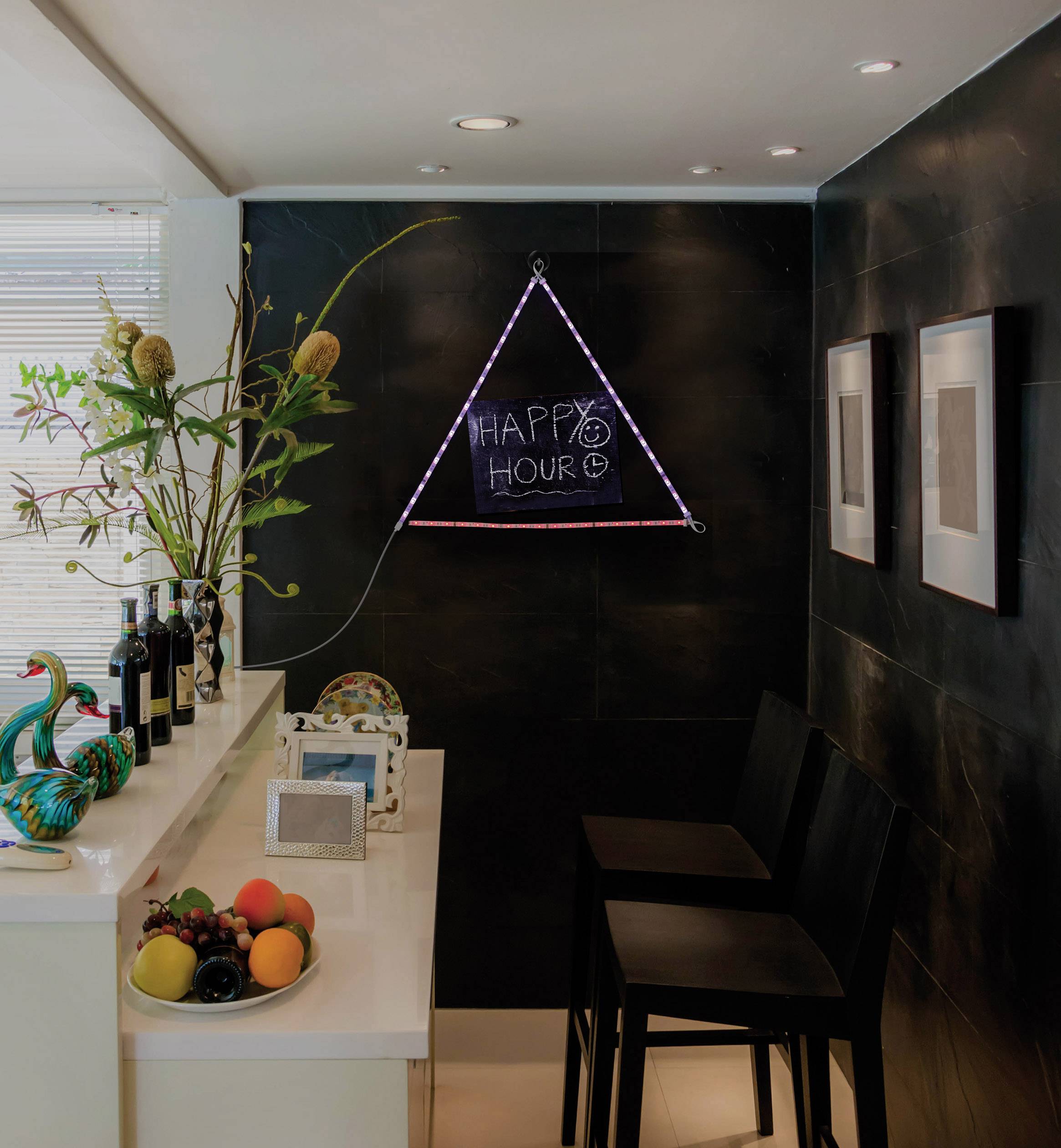 A small bar corner with two black chairs and a bar counter. A glowing sign on the wall displays 'HAPPY HOUR'.