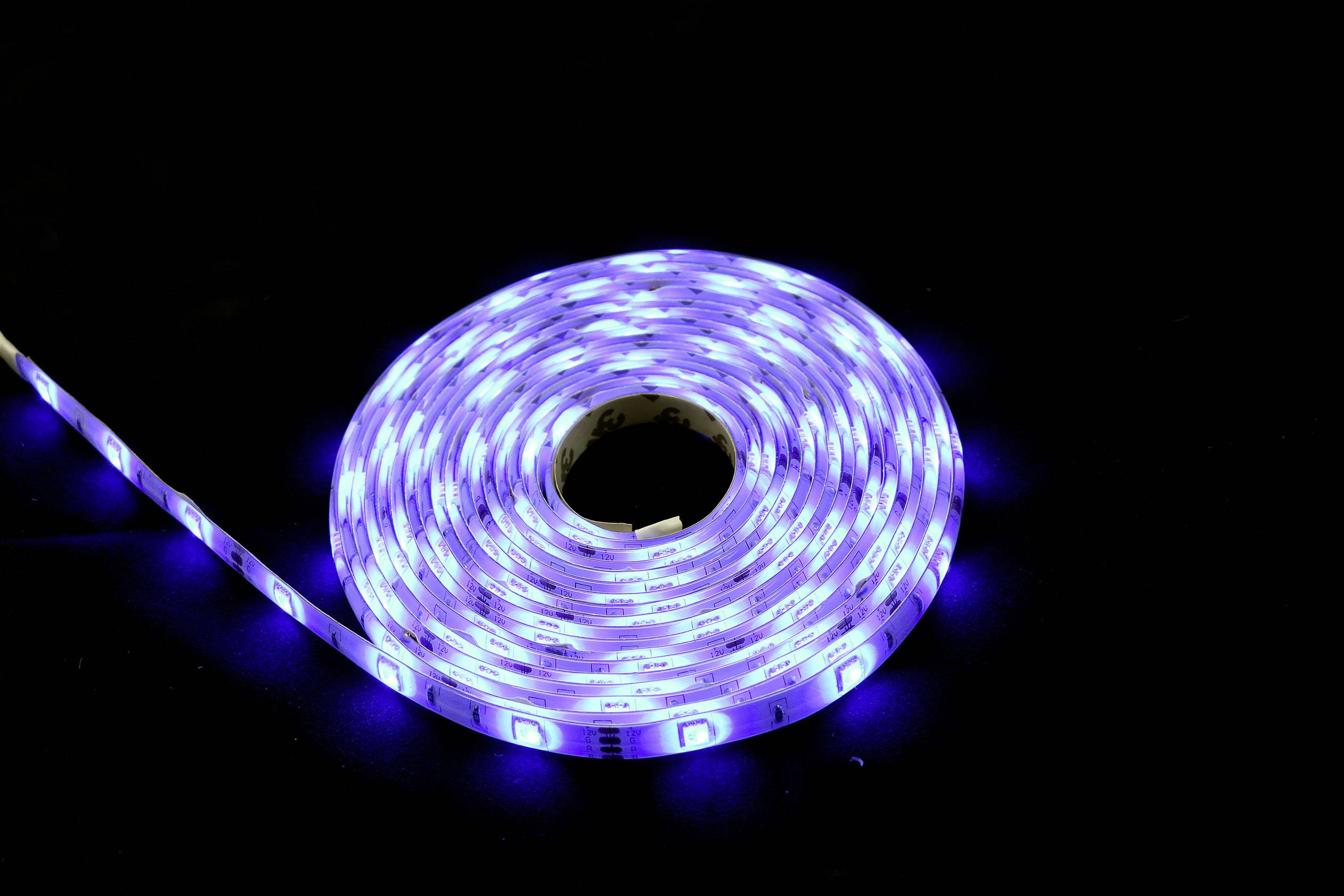 A coiled, glowing LED light string with blue light on a black background.