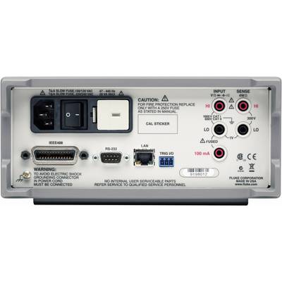Back of an electronic device with multiple ports and warning labels. Markings indicate voltages and safety specifications.