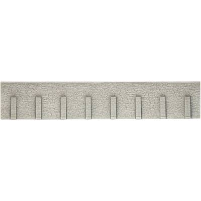 A grey brick wall with vertical supports at regular intervals. The surface appears rough and textured.