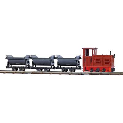 Toy steam locomotive with three black coal wagons on a railway track. Locomotive in red colour, model railway layout.
