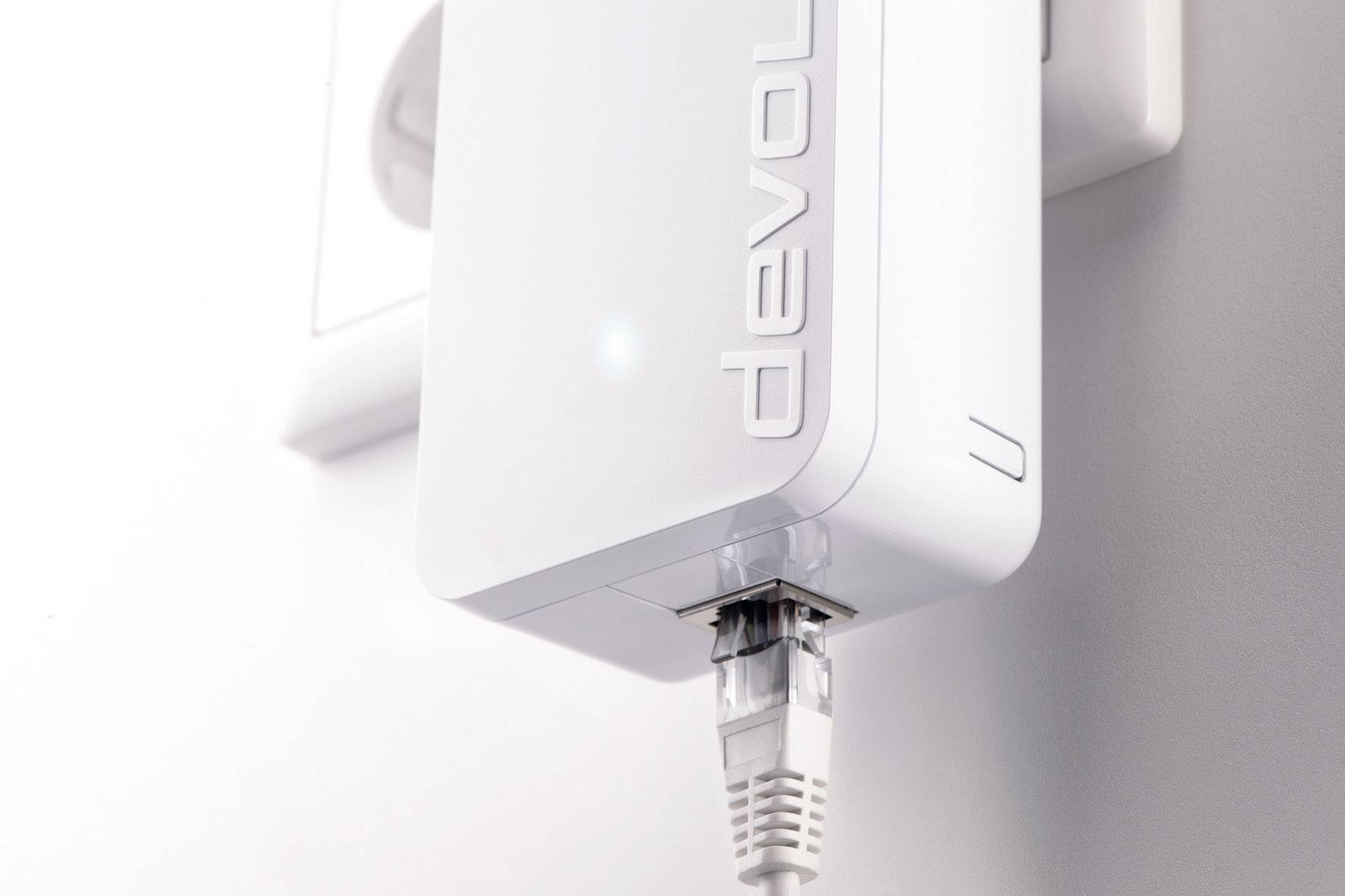 A white powerline adapter, plugged into a socket, with an Ethernet cable connected for internet connectivity.