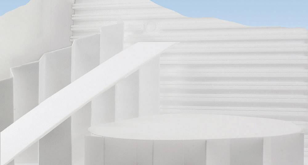 Abstract white structure with stairs and platforms against a blue sky. Futuristic architecture with pronounced minimalism.