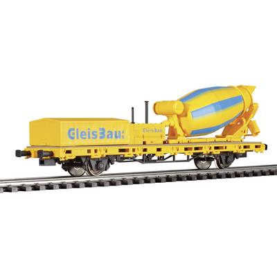A yellow train carriage with a blue and yellow concrete mixer, bearing the inscription 'Track Construction', is travelling along railway tracks.