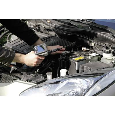 A person is checking the car's engine with a diagnostic device. The bonnet is open, and the device is displaying data on a screen.