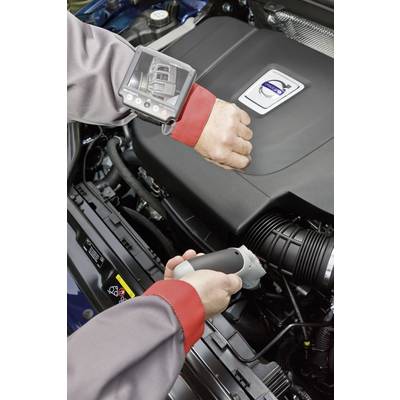 A mechanic inspects a car engine with a handheld device. A screen on the wrist displays details of the engine.