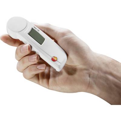 A hand is holding a device with a digital display used for temperature measurements.
