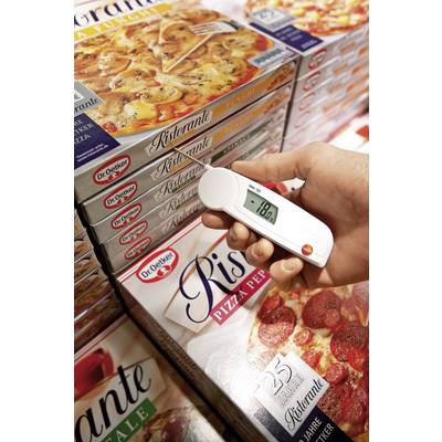 A hand measures the temperature of a frozen pizza packet in the supermarket freezer cabinet using a digital thermometer.