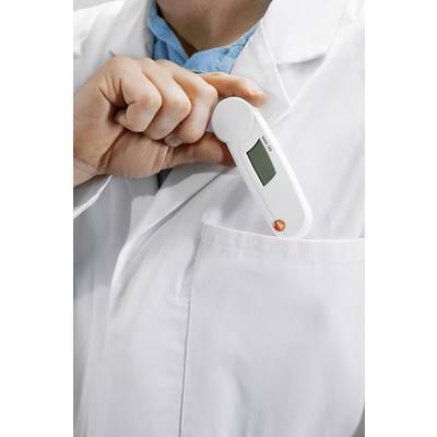 A person in a white lab coat is slipping a digital thermometer into their breast pocket.