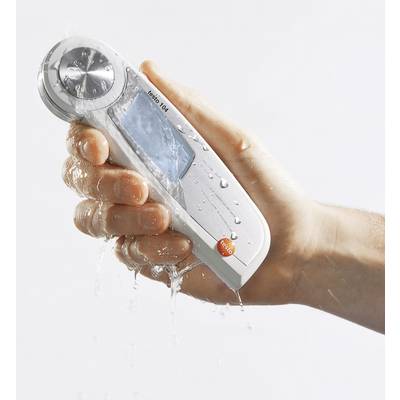 A hand holds a waterproof digital thermometer being splashed by water, demonstrating its water resistance.