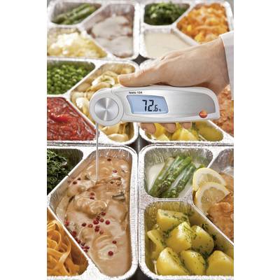 A hand thermometer measures the core temperature of chicken at 72.6°C in an aluminium tray, surrounded by various dishes.
