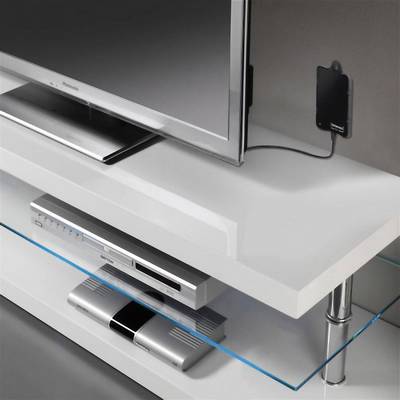 A modern television sits on a white TV stand, with a DVD player and another electronic device placed on a glass shelf underneath.