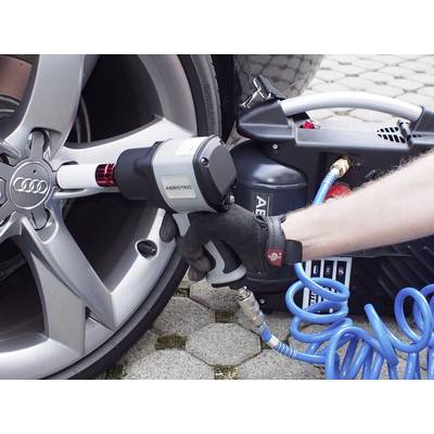 A mechanic is changing a tyre on a car using a pneumatic impact wrench.