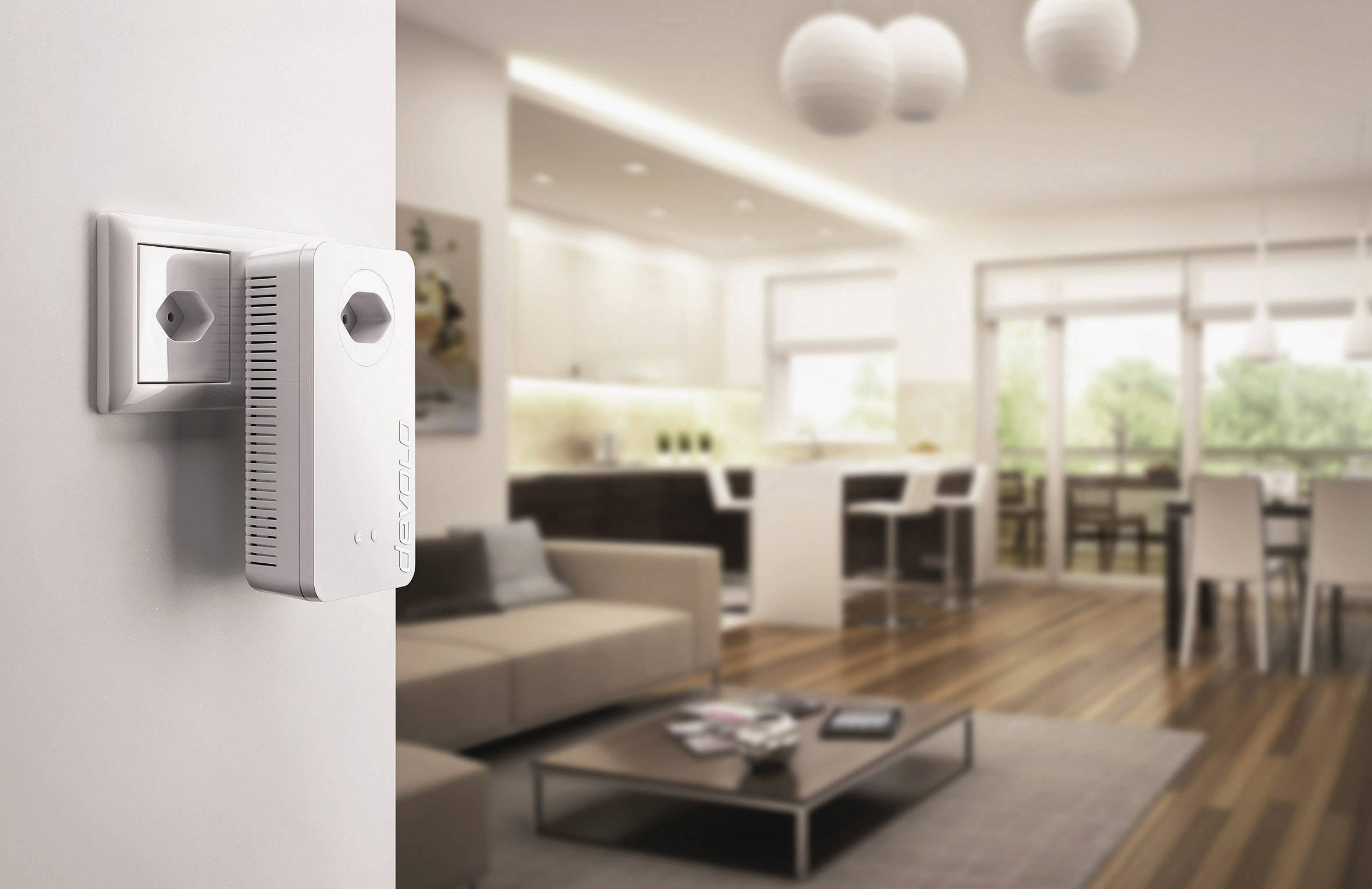 A white Wi-Fi repeater is plugged into a socket in a modern living room, which is furnished with a sofa, coffee table, and dining table.