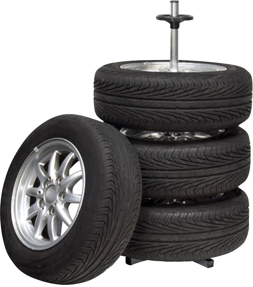 Four car tyres with rims, stacked three high, with a fourth leaning against the side.