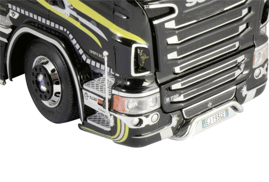 Close-up of the right front side of a black lorry model with yellow and white stripes and detailed paintwork.