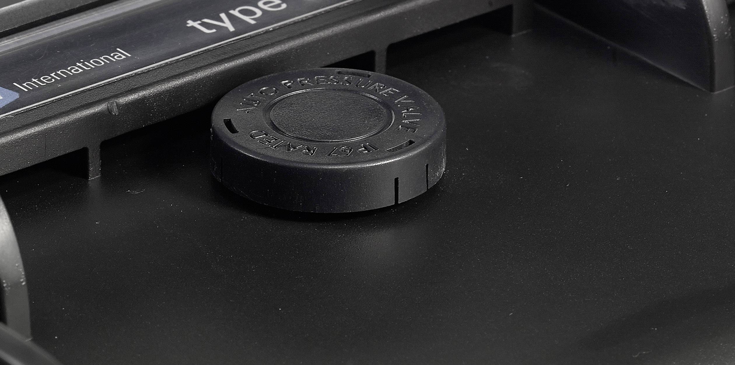 A round black lid on a black surface, possibly part of a printer or photocopier.