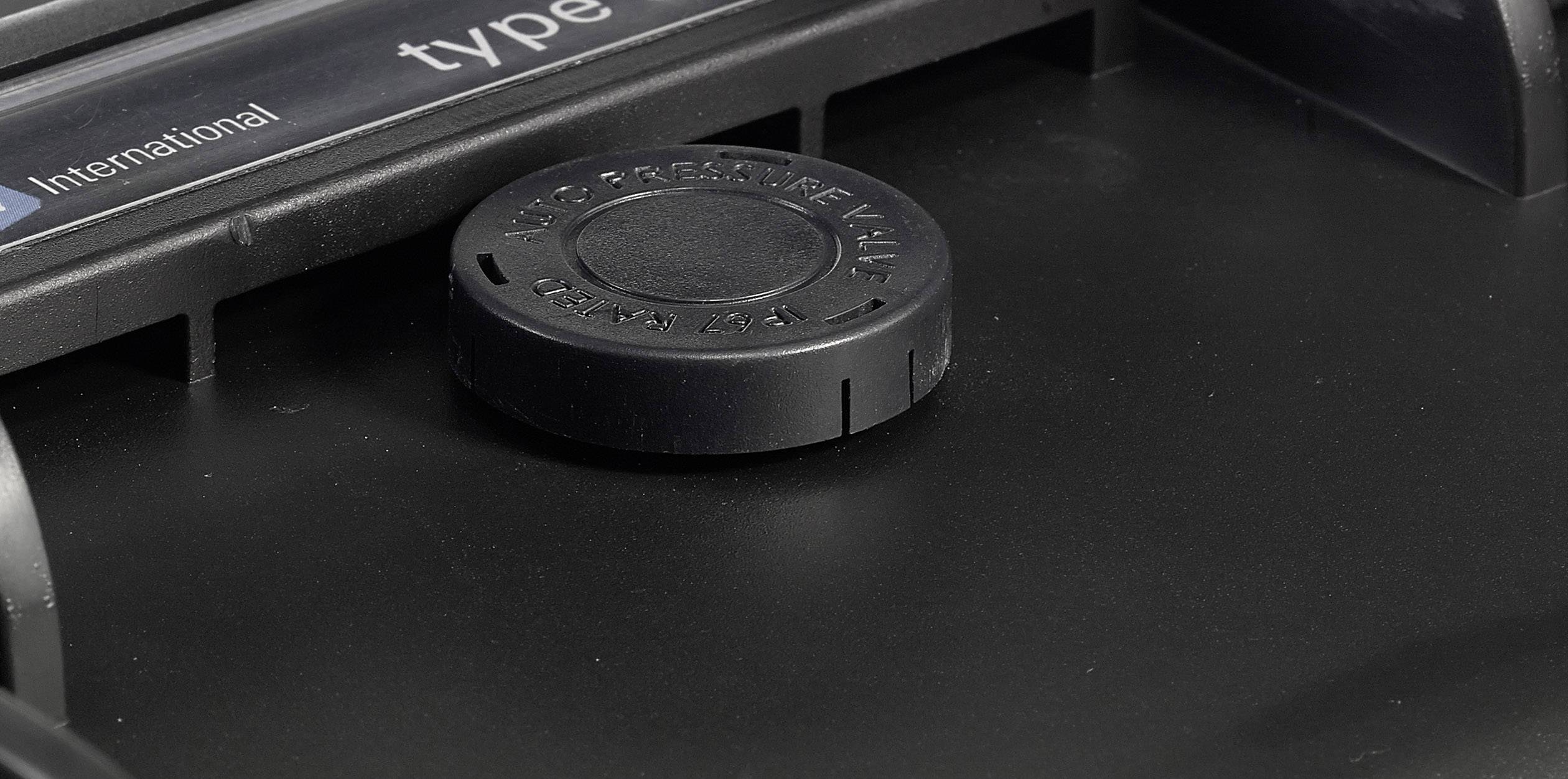 Black plastic lid on a device, surrounded by safety warnings.