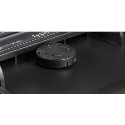 A black measuring attachment with the inscription 'Type International' on a device, presumably used for calibration or adjustment.