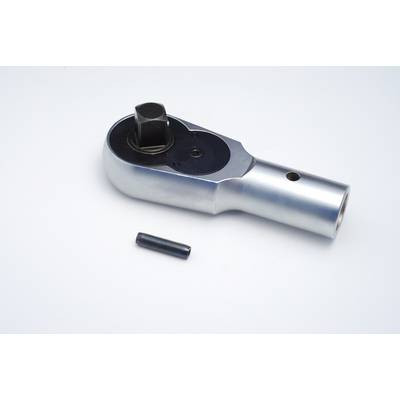 A silver ratchet head lies on a white background, next to a pen.