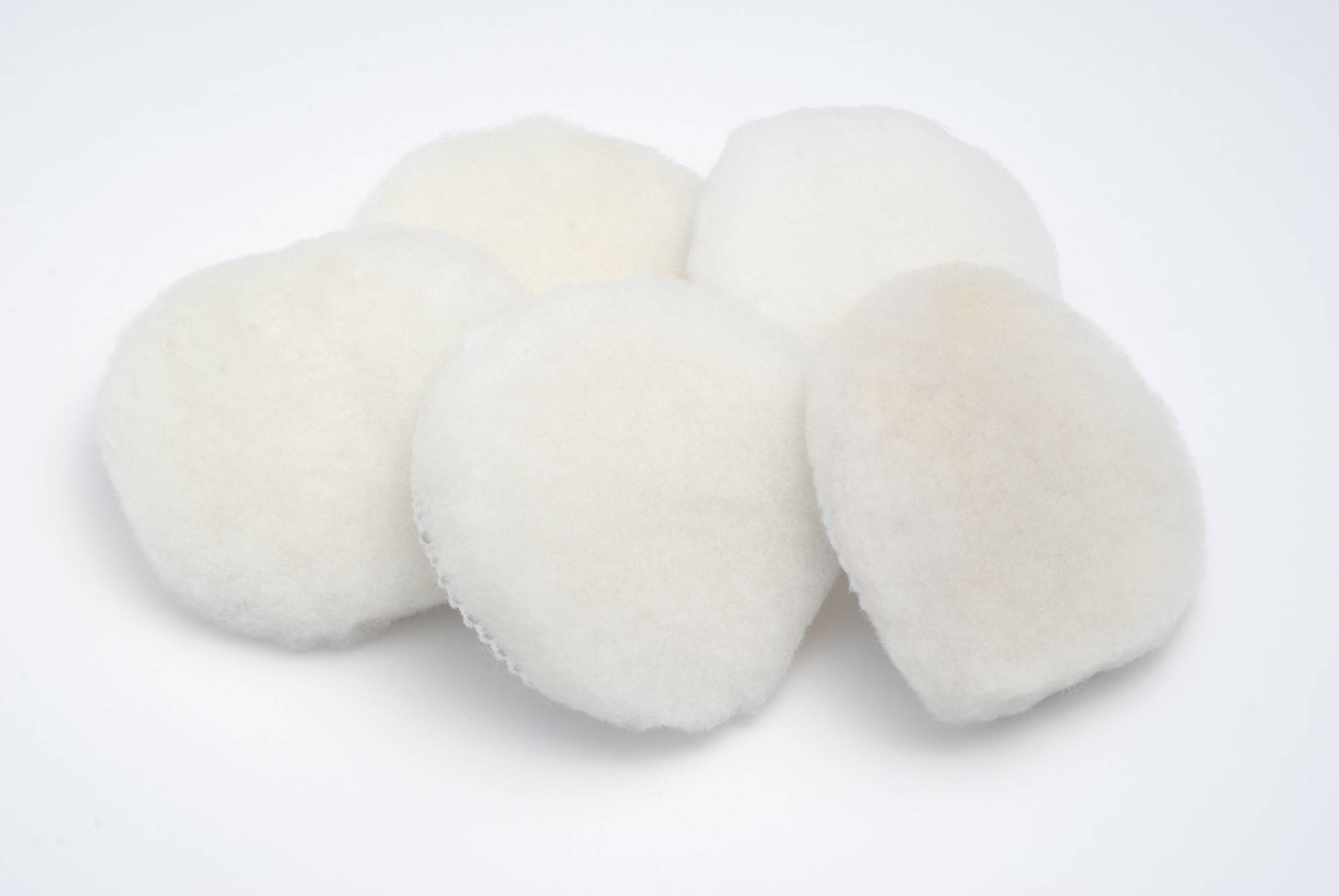 Five round, fluffy, white pads on a white background. They look like small, soft cushions.