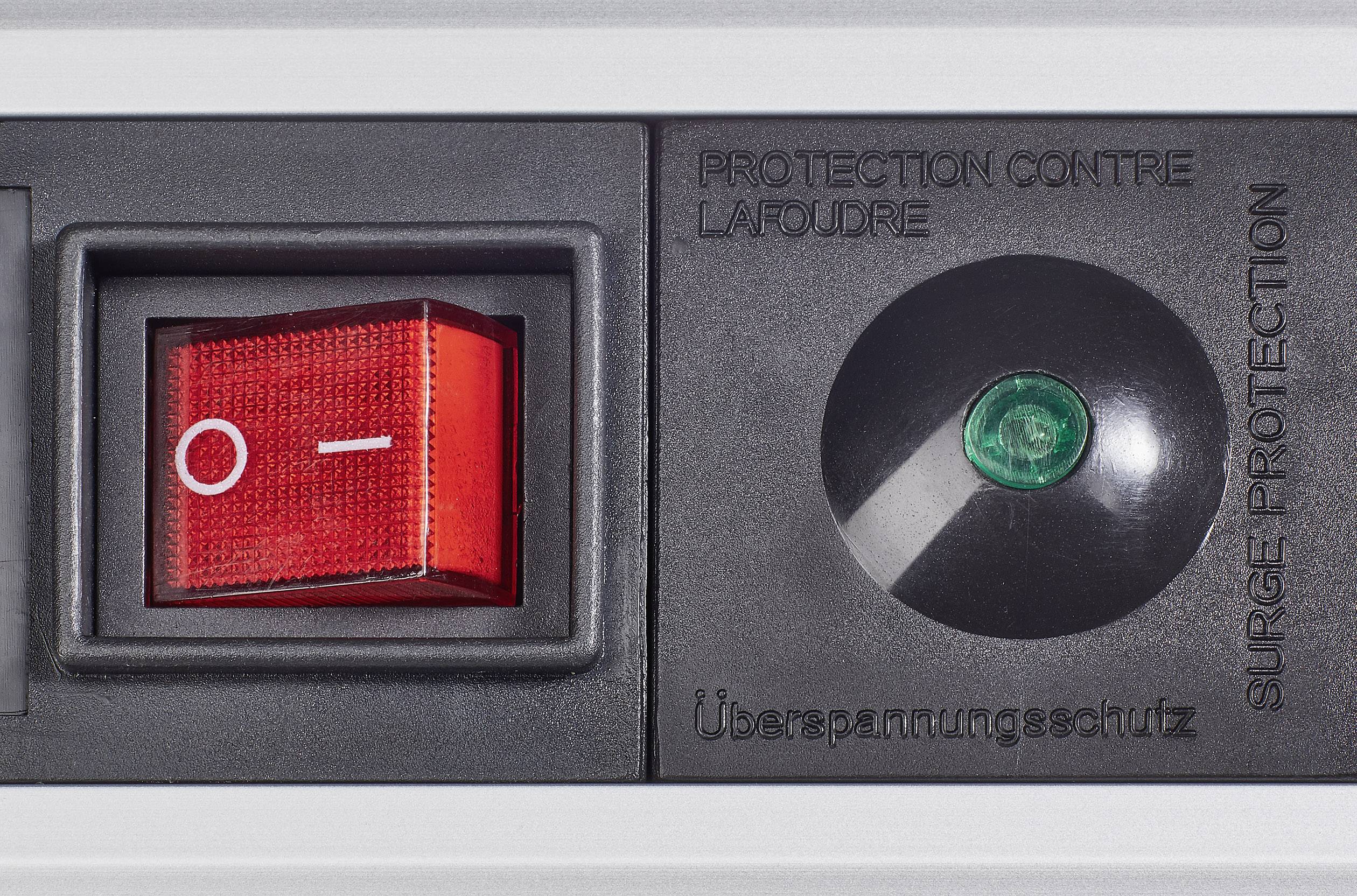 Switch with a red toggle switch and green indicator light on a surge protection strip, with French, German and English indication of surge protection.