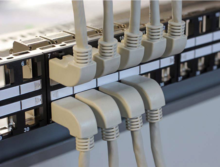 A network patch panel with nine connected Ethernet cables. It demonstrates the organisation and interconnection of network cables.