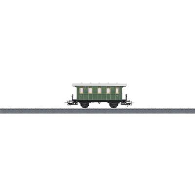 A green historical railway carriage with cream-coloured windows stands on a track.