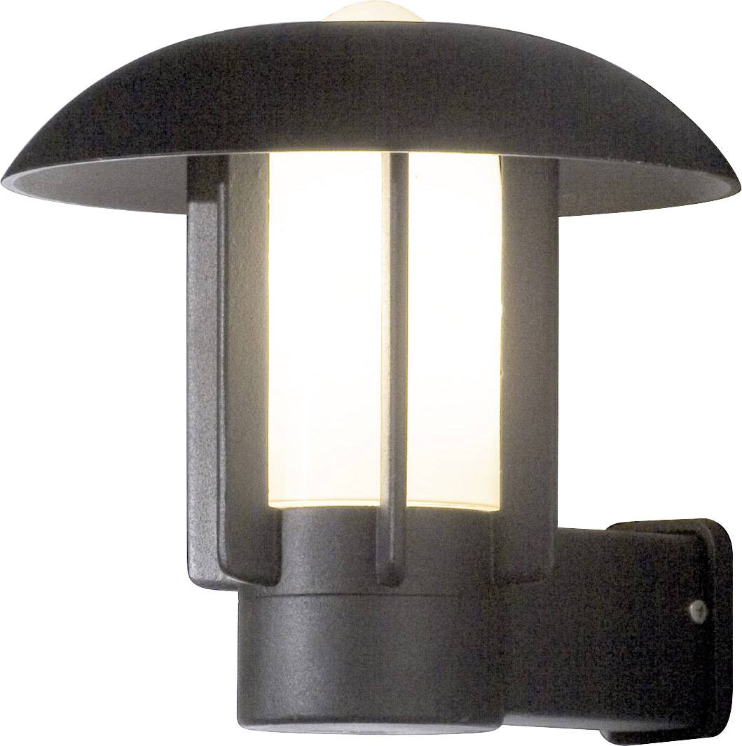 Modern black exterior wall light with a matte glass cylinder. The light emits soft, warm illumination, suitable for patios or entrances.