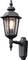 Black wall lantern with classic design, emitting warm light. It is mounted on a decorative bracket.
