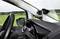 An action camera is mounted inside a car on the windscreen, with green landscape in the background.