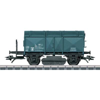 Small model of a green goods wagon on railway tracks, side view, with detailed decorations and inscriptions on the wagon's side.