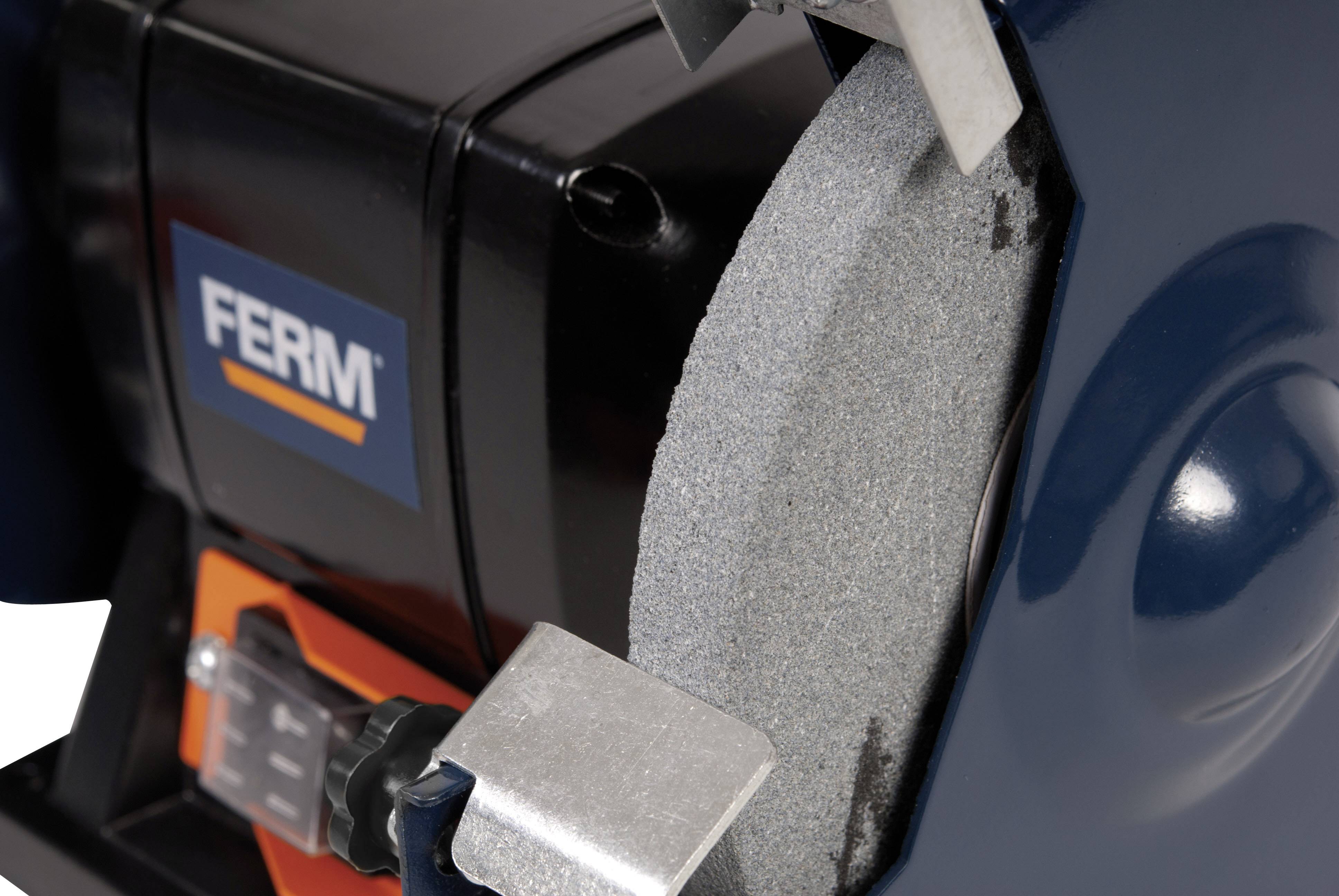Close-up of a grinding bench with a visible grinding wheel and safety guard. The brand name 'FERM' can be seen on the machine.