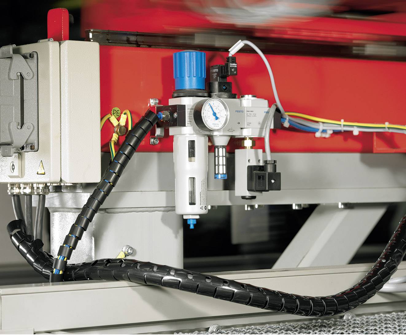 An industrial compressed air system with a pressure gauge and blue, black and white components, mounted on a metal frame.