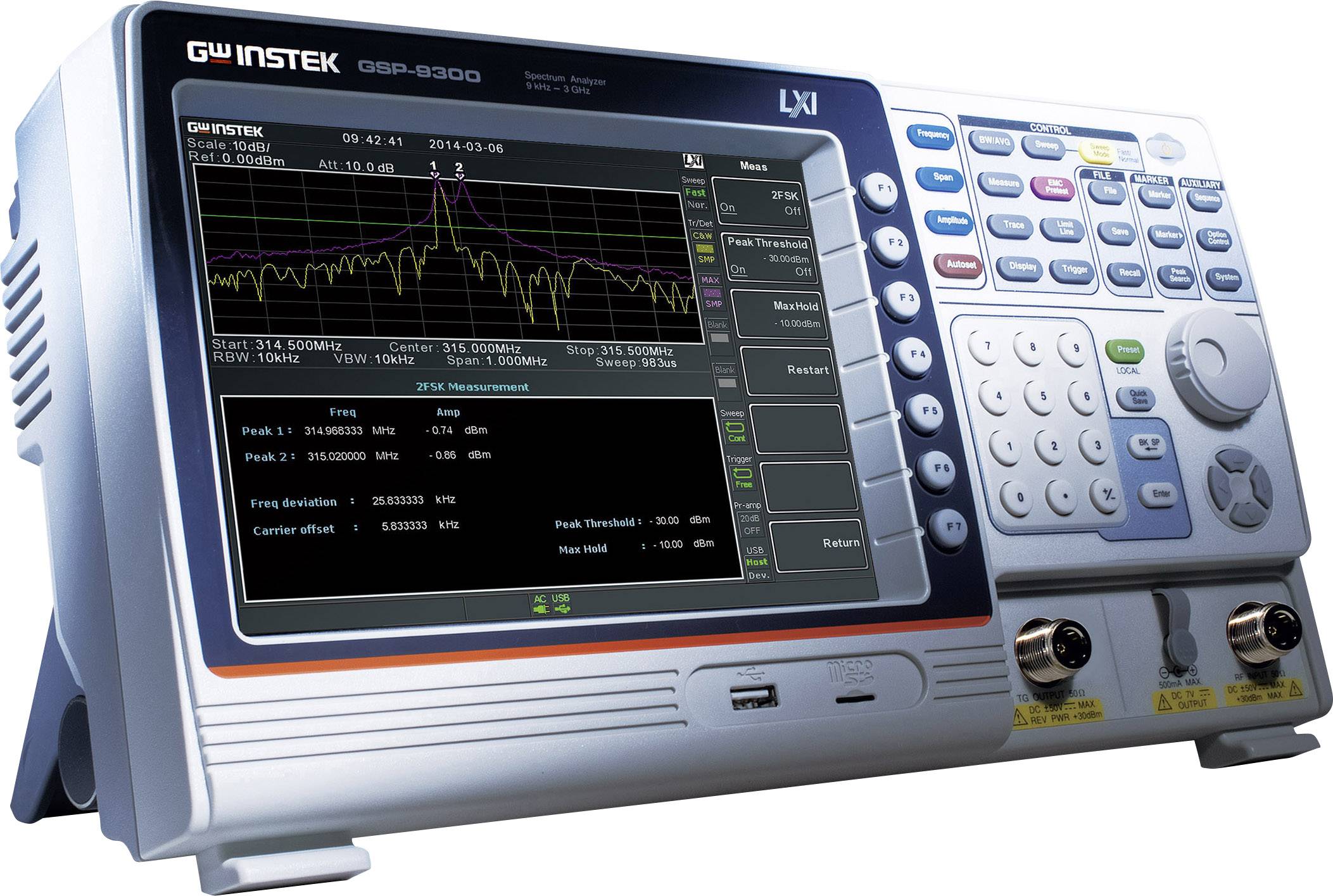 A spectrum analyser with a digital display shows frequency graphs and measurement values. Various control elements are visible.