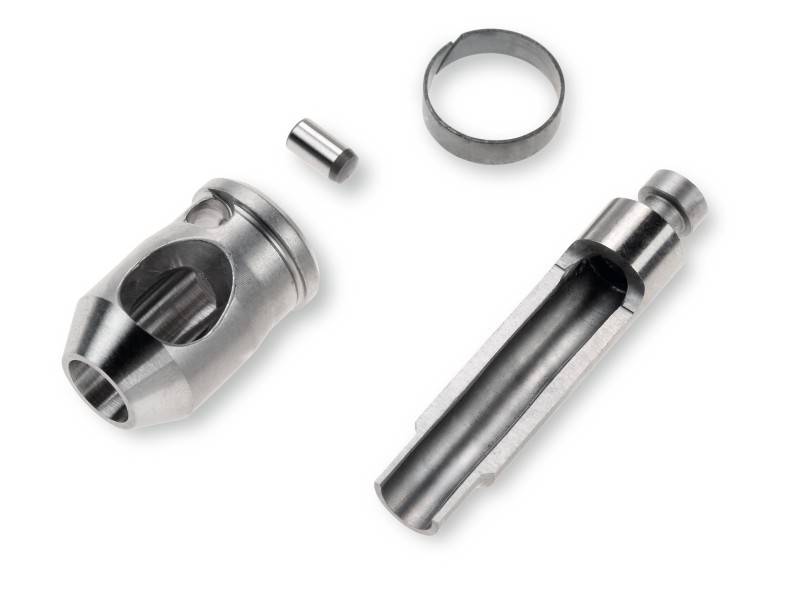 Metal components of a mechanical part, including a cylindrical housing, a small pin and a ring.