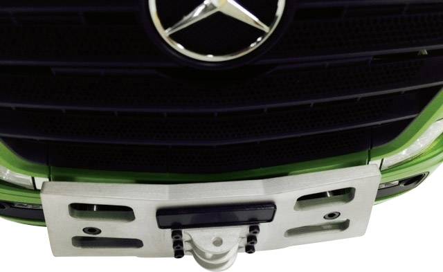 Front view of a green vehicle with a Mercedes-Benz star on the radiator grille and a number plate holder beneath it.
