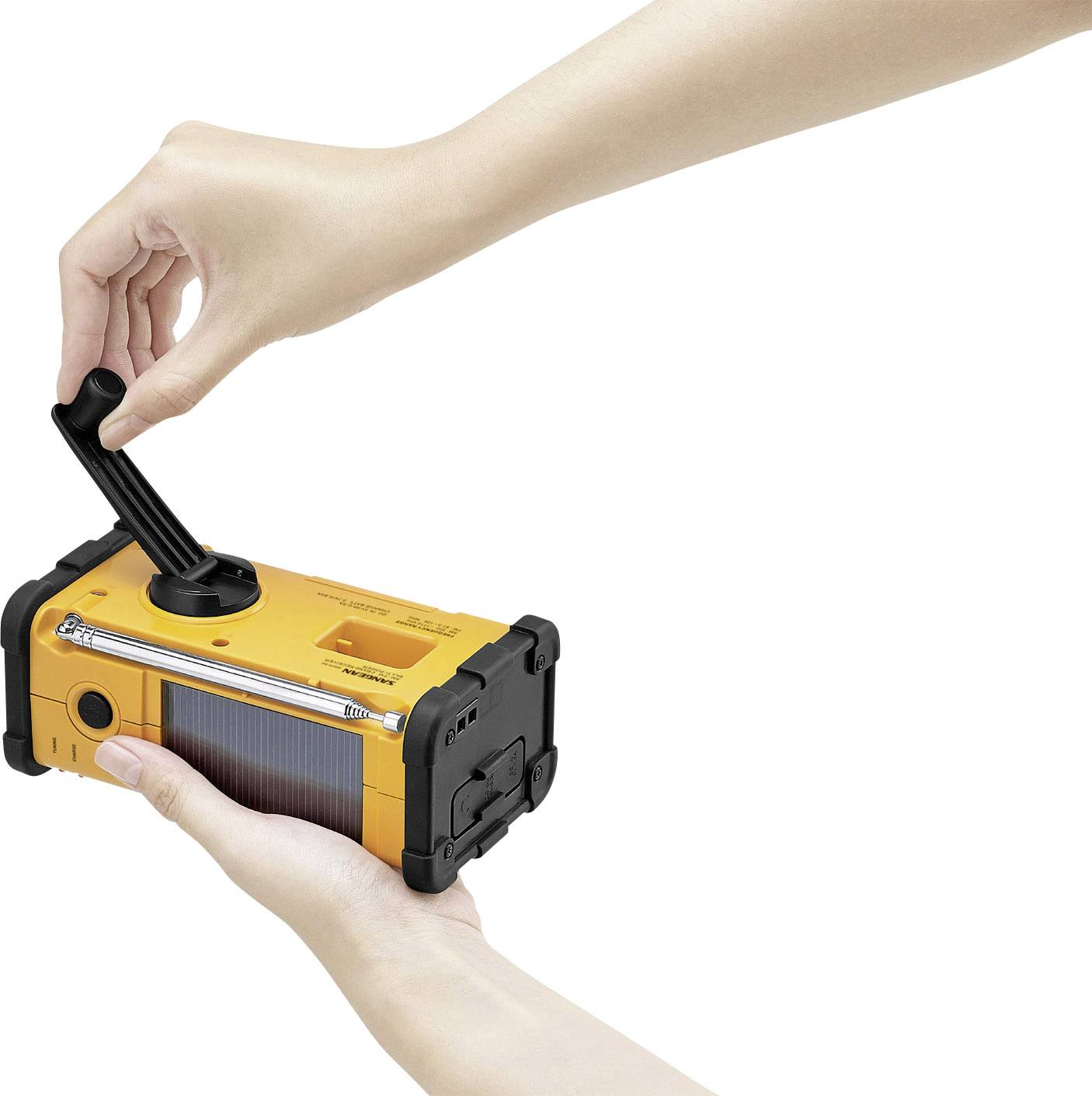 A hand is manually cranking a yellow emergency radio with a solar panel and torch, which is being held in another hand.