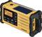Portable, yellow hand-crank radio with display and solar panel. Shows frequency '100.7'. Corners protected in black, USB port visible.