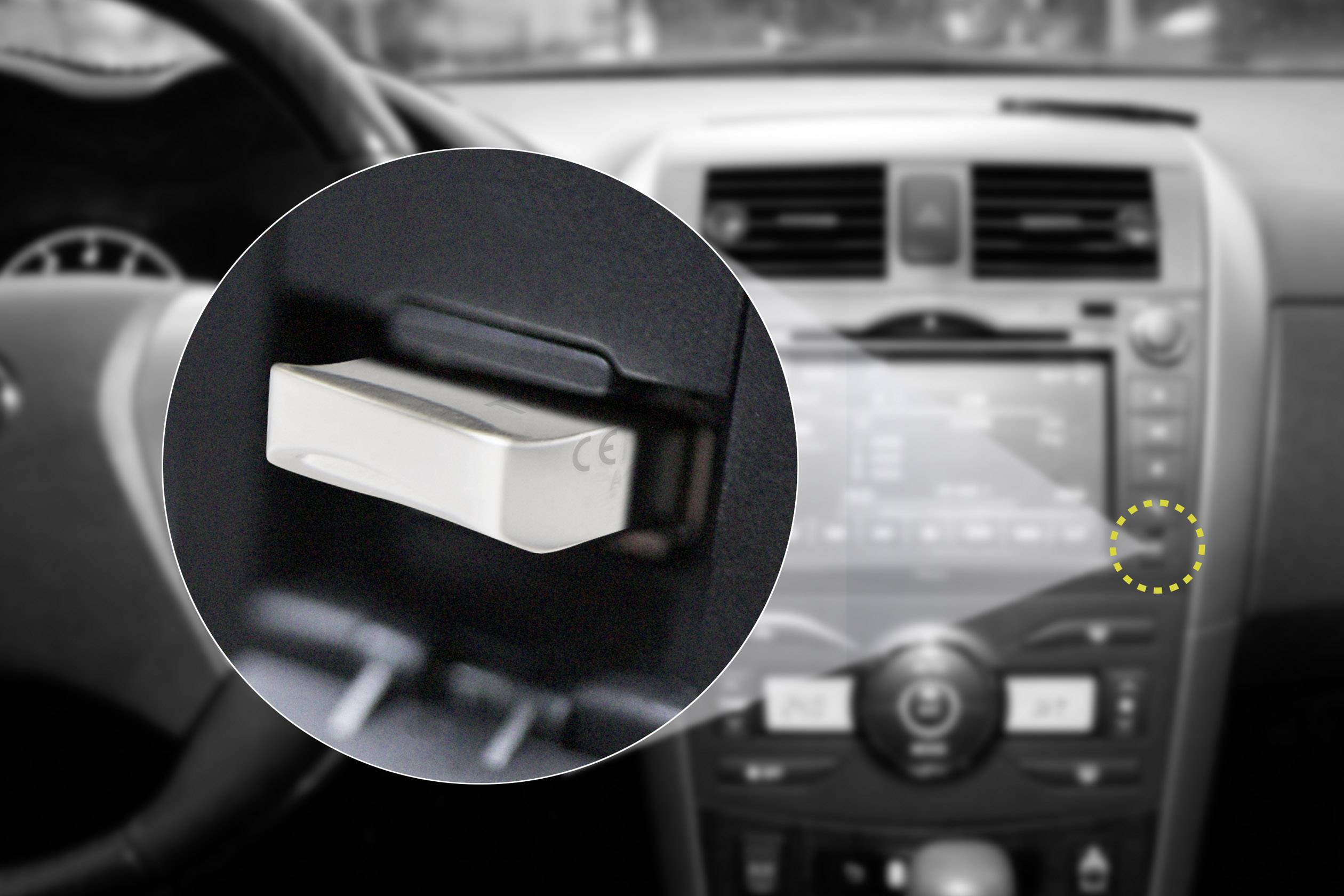 Close-up of a USB stick connected to an infotainment system in a vehicle, with controls and display in the background.