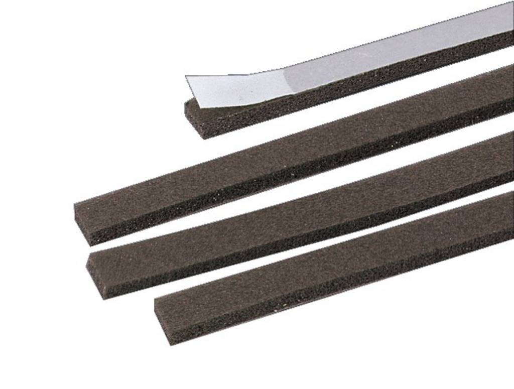 'Several foam strips, one with a removable protective film, arranged on a light surface.'