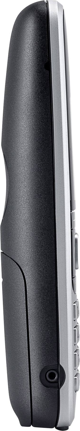Side view of a mobile telephone with a black back and silver frame, showing buttons and ports at the bottom.
