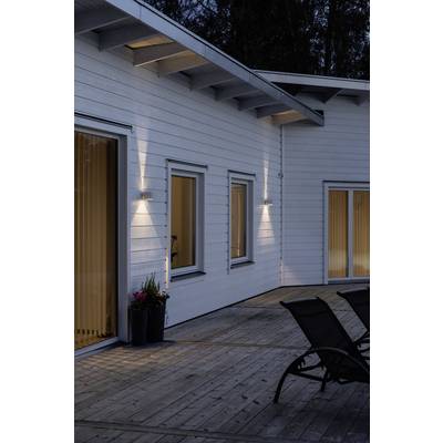 Modern white wooden house at dusk. Exterior lighting is switched on and gives the building an inviting atmosphere.