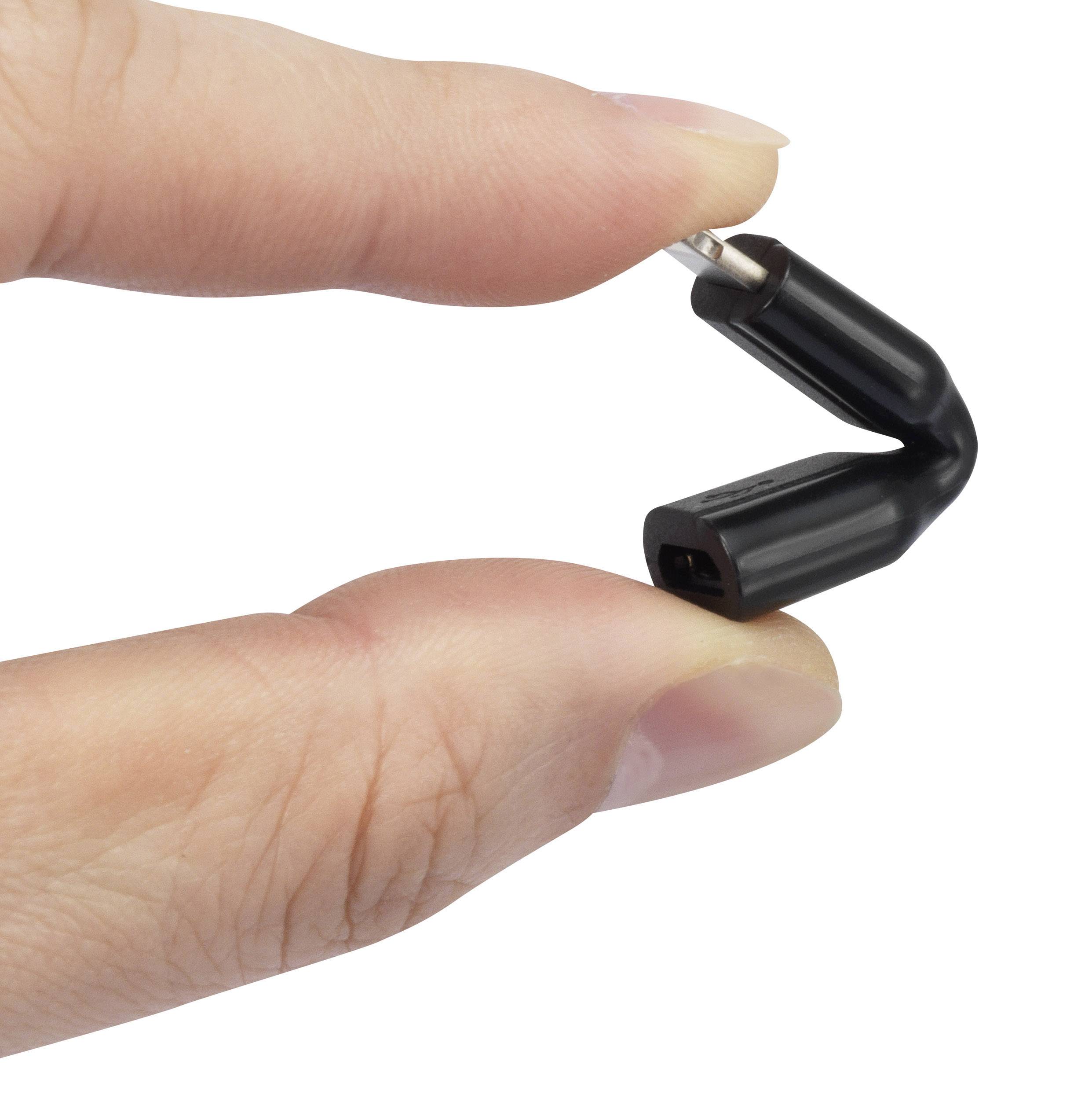A hand holds a small black bit holder between the thumb and index finger.