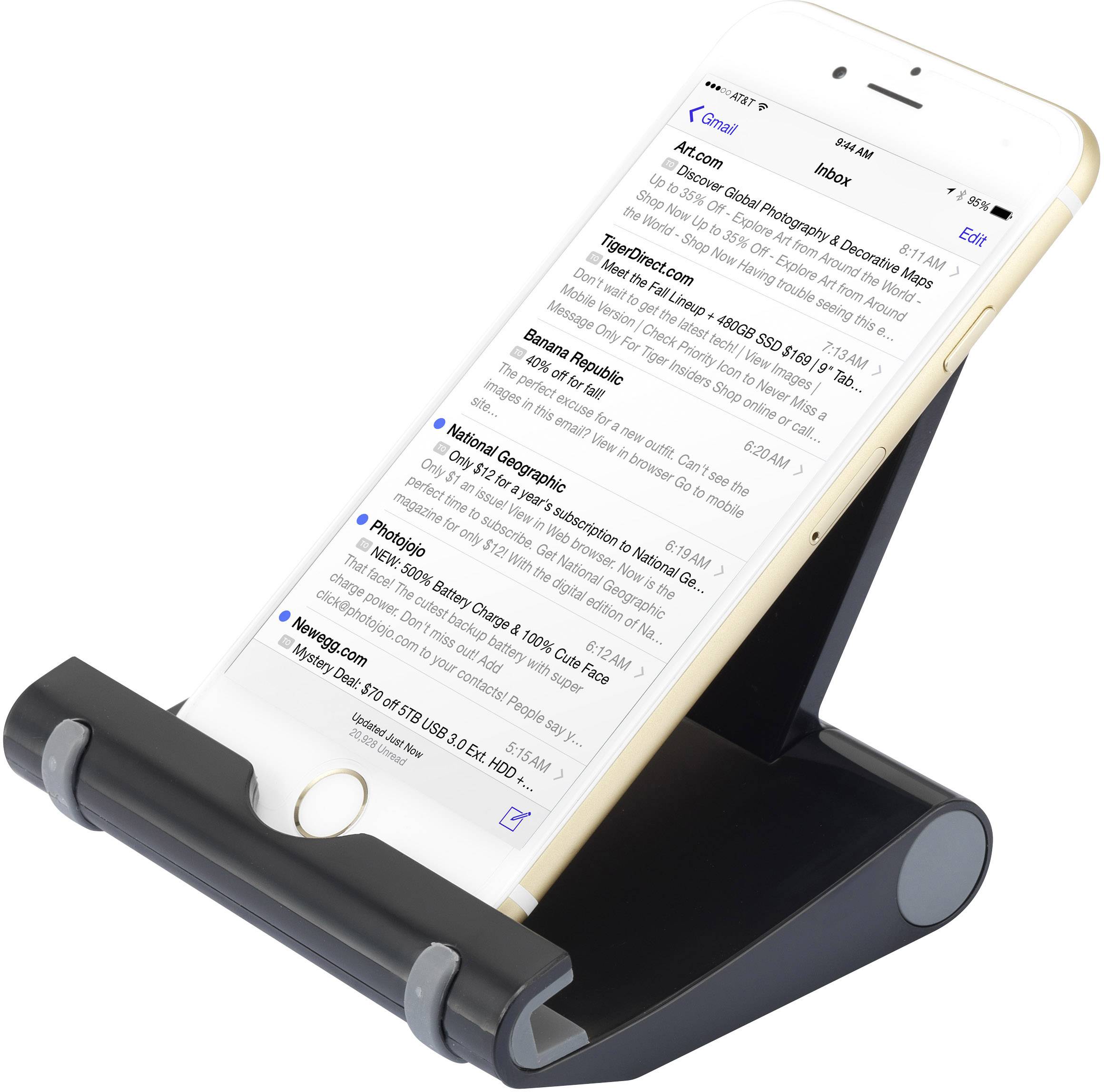A smartphone is standing on a stand, displaying an open email app with messages visible in the inbox.